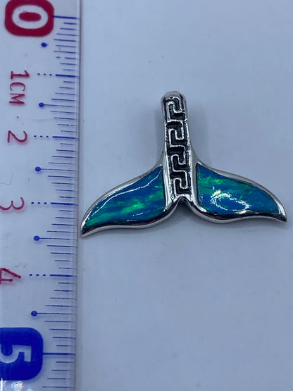 Dije de plata con ópalo sobre fondo blanco mostrando el tamaño real (2.6 cm) al lado de una regla