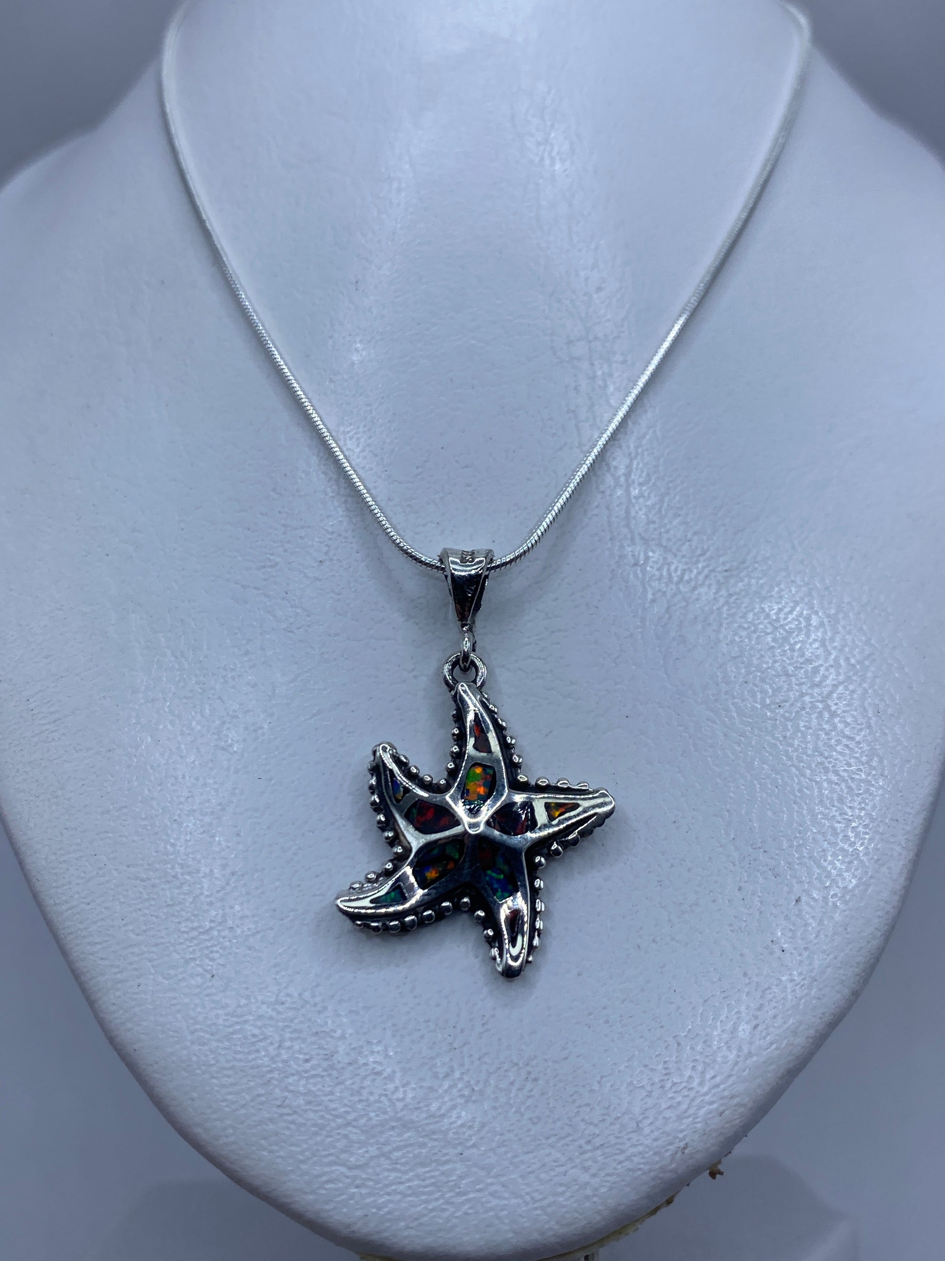 Estrella de mar granulada de plata .950 sobre cuello blanco, tamaño real de 4 centímetros