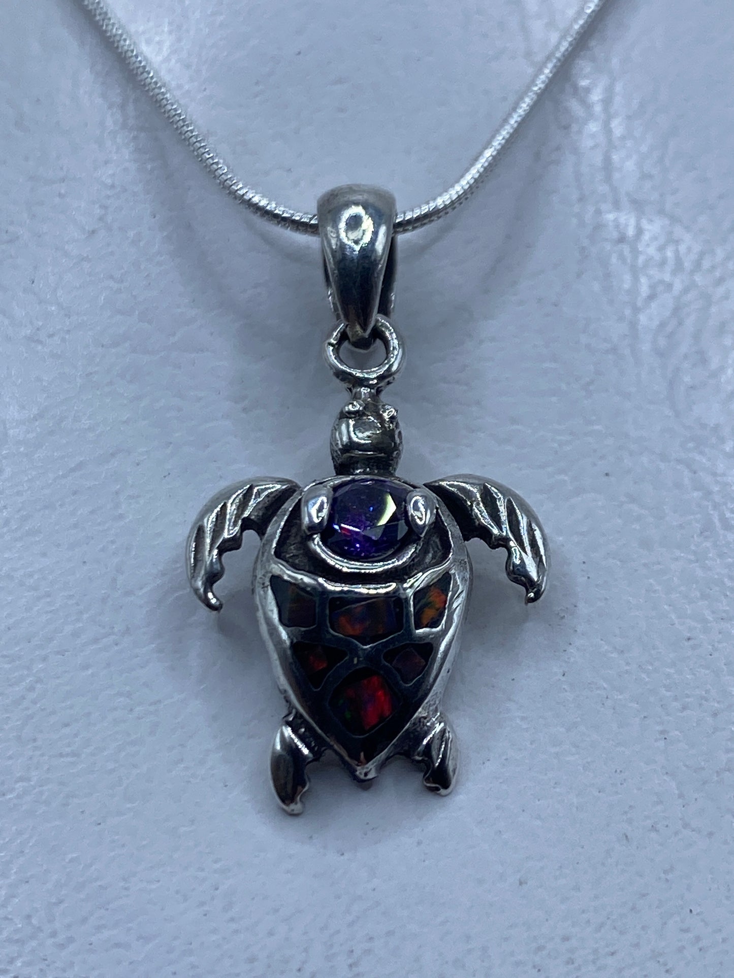 Dije tortuga de plata .925 con ópalo de fuego multicolor colgando de cadena de plata