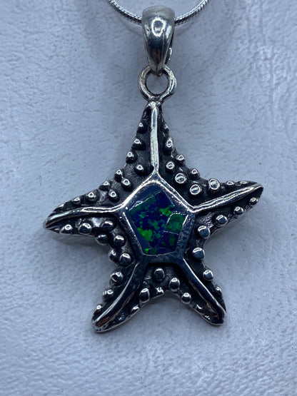 Dije estrella de plata con ópalo de fuego azul, colgando de cadena de eslabones
