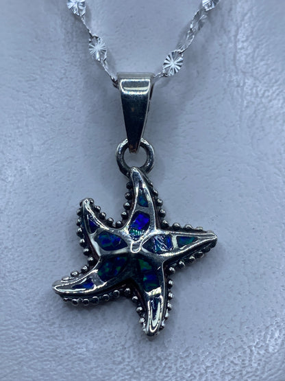 Dije de estrella marina en plata .950 con ópalo de fuego azul engastado a mano, colgando de cadena ornamental