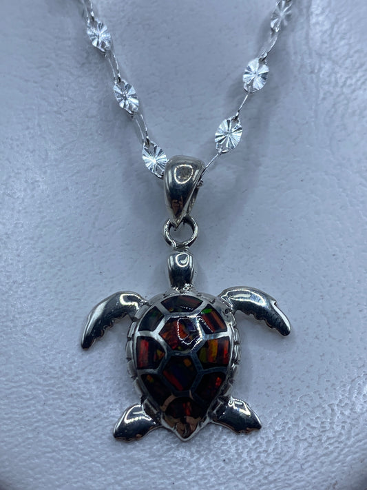 Dije de tortuga marina en plata .950 con ópalo de fuego multicolor engastado, colgado de cadena con beads de plata
