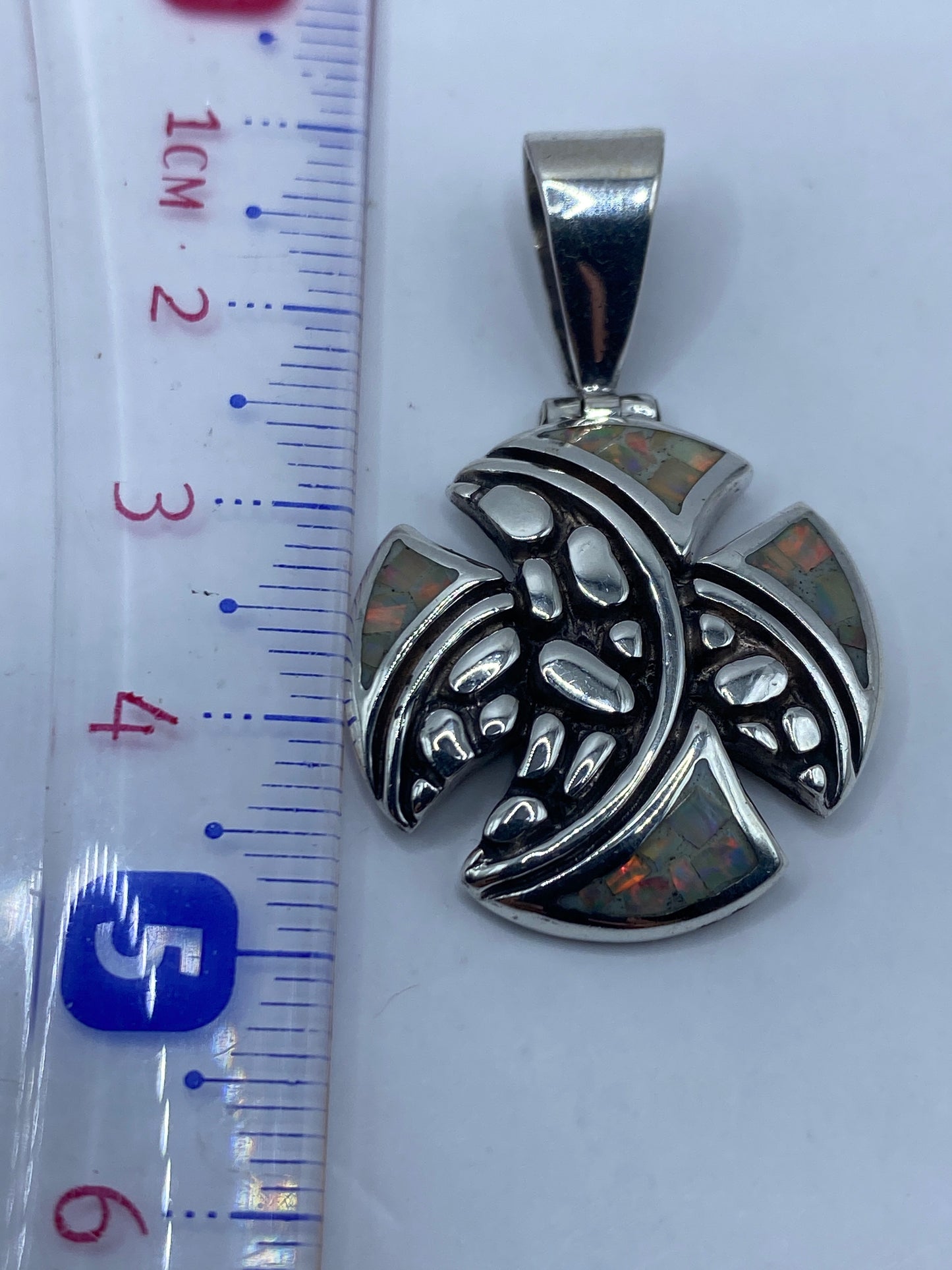 Medición del dije: 4.6 cm de largo junto a regla