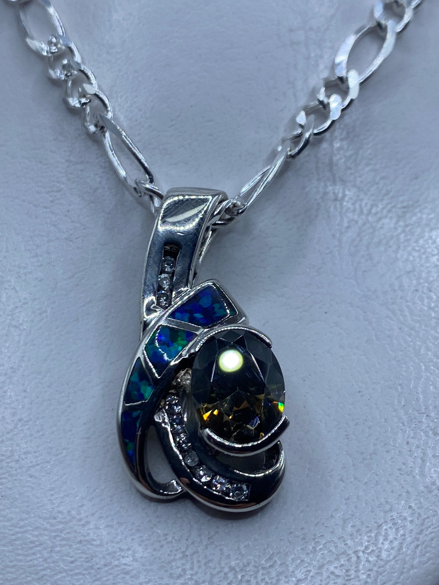 Dije de plata con ópalo de fuego azul colgando de una cadena de plata .925