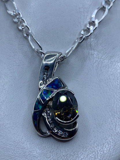 Dije de plata con ópalo de fuego azul colgando de una cadena de plata .925
