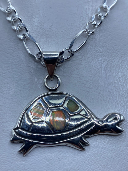 Dije tortuga en plata .925 con ópalo de fuego multicolor sobre cadena plateada