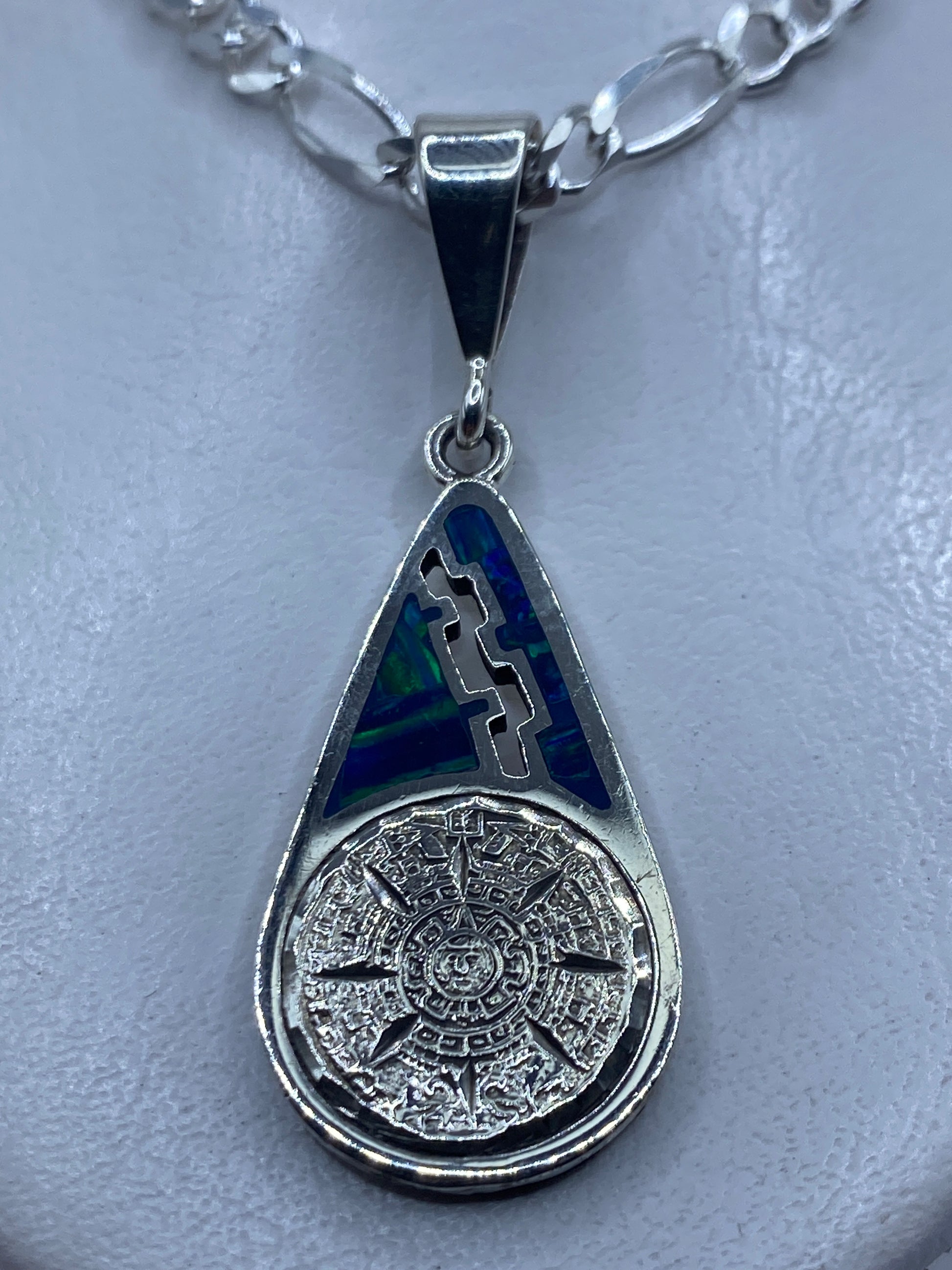 Dije de plata .950 con Piedra del Sol azteca e incrustaciones de ópalo de fuego azul