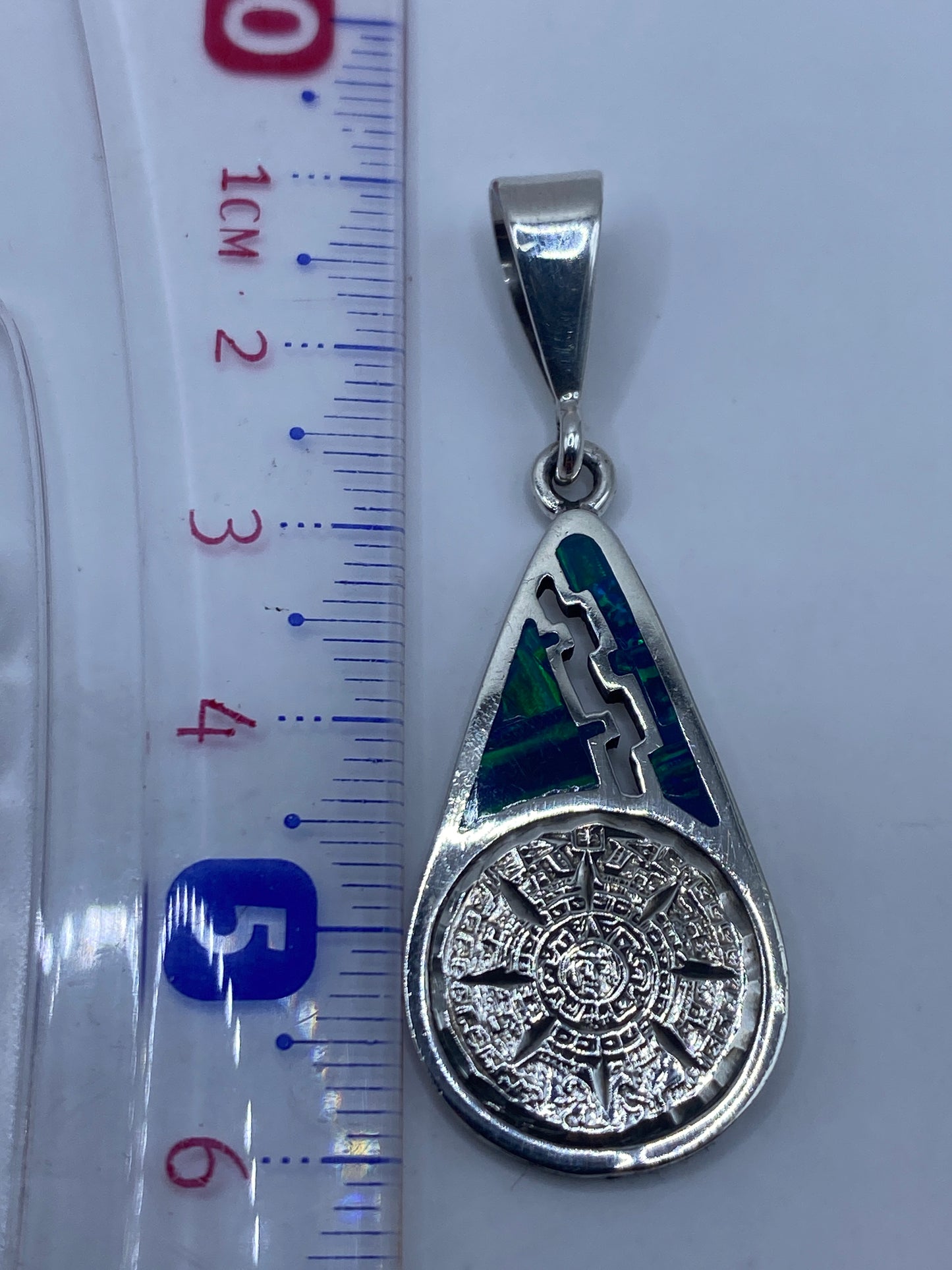 Dije sobre cinta de medición mostrando 5.9 cm de largo, tamaño real