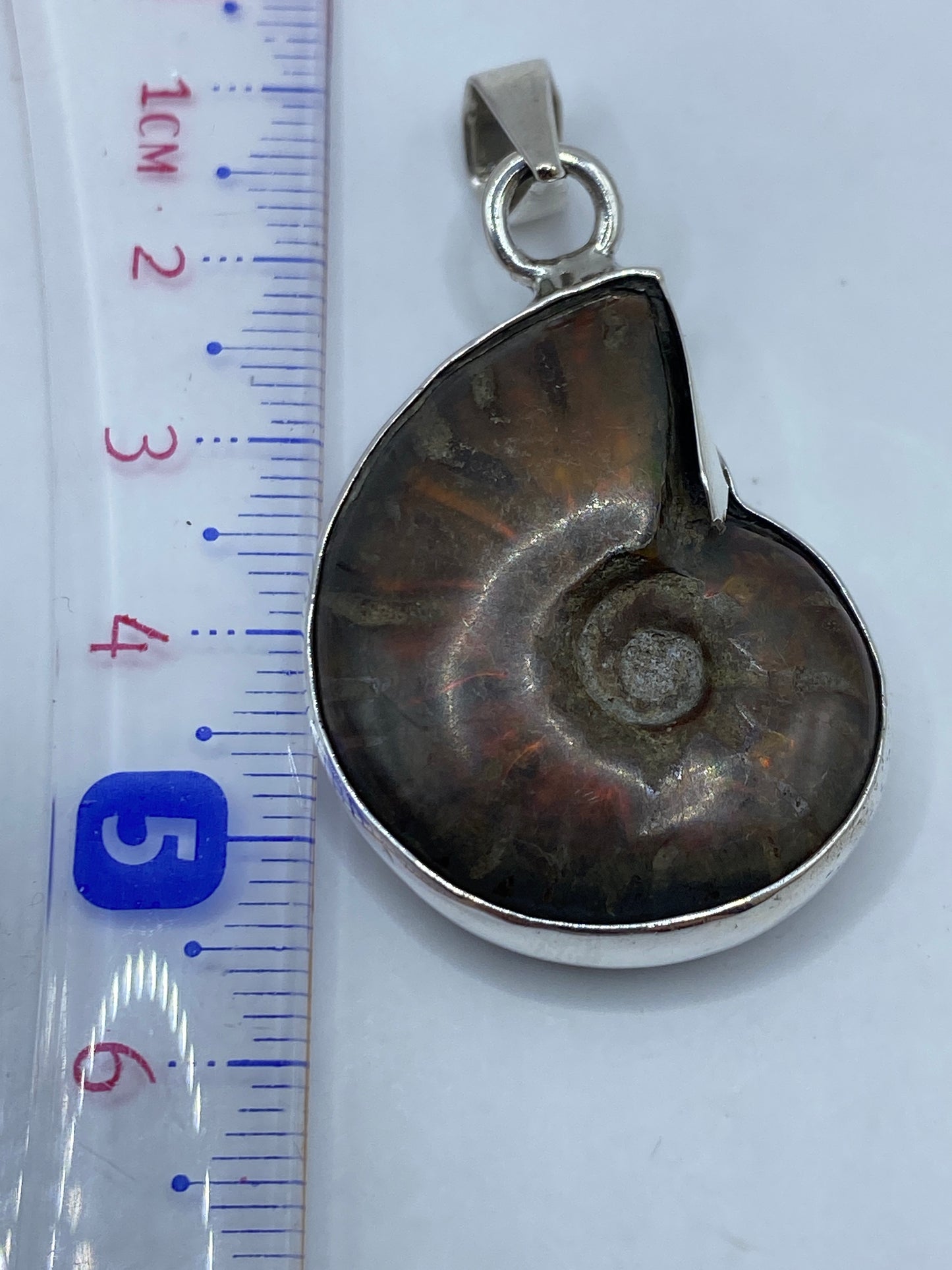 Medida del dije de 5.7 cm sobre regla de centímetros