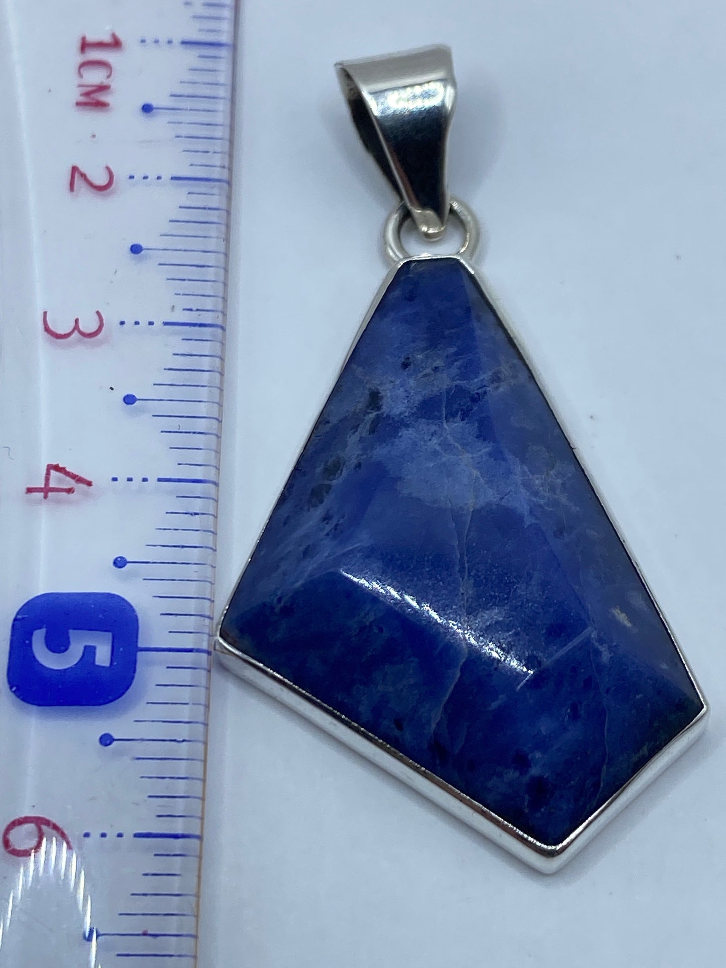 Dije sobre regla centimétrica mostrando 6 cm de largo sin cadena