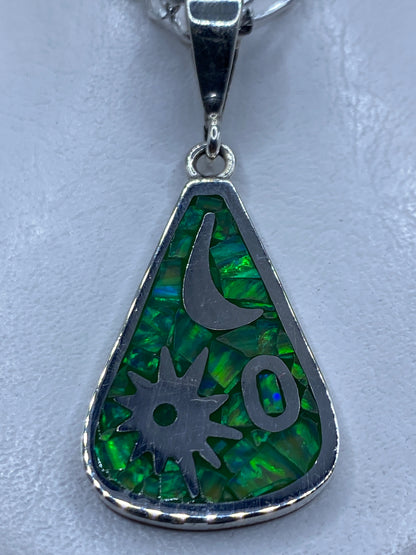 Dije de plata con ópalo de fuego verde limón y símbolos Luna y Medicina, colgado de una cadena plateada