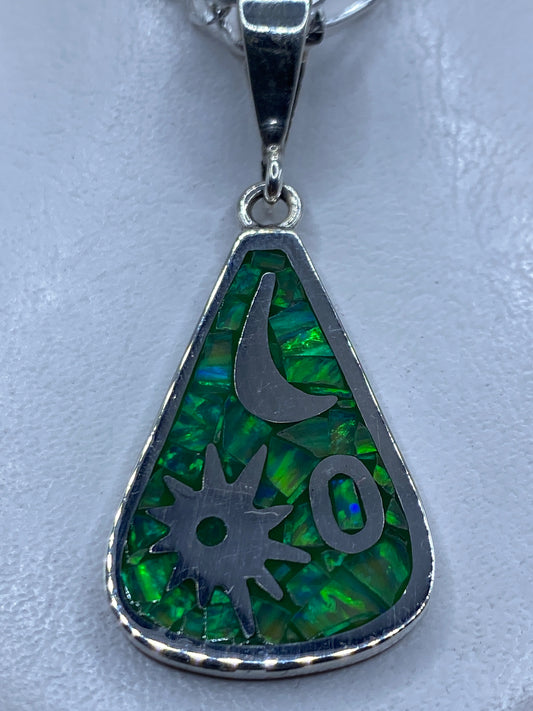 Dije de plata con ópalo de fuego verde limón y símbolos Luna y Medicina, colgado de una cadena plateada