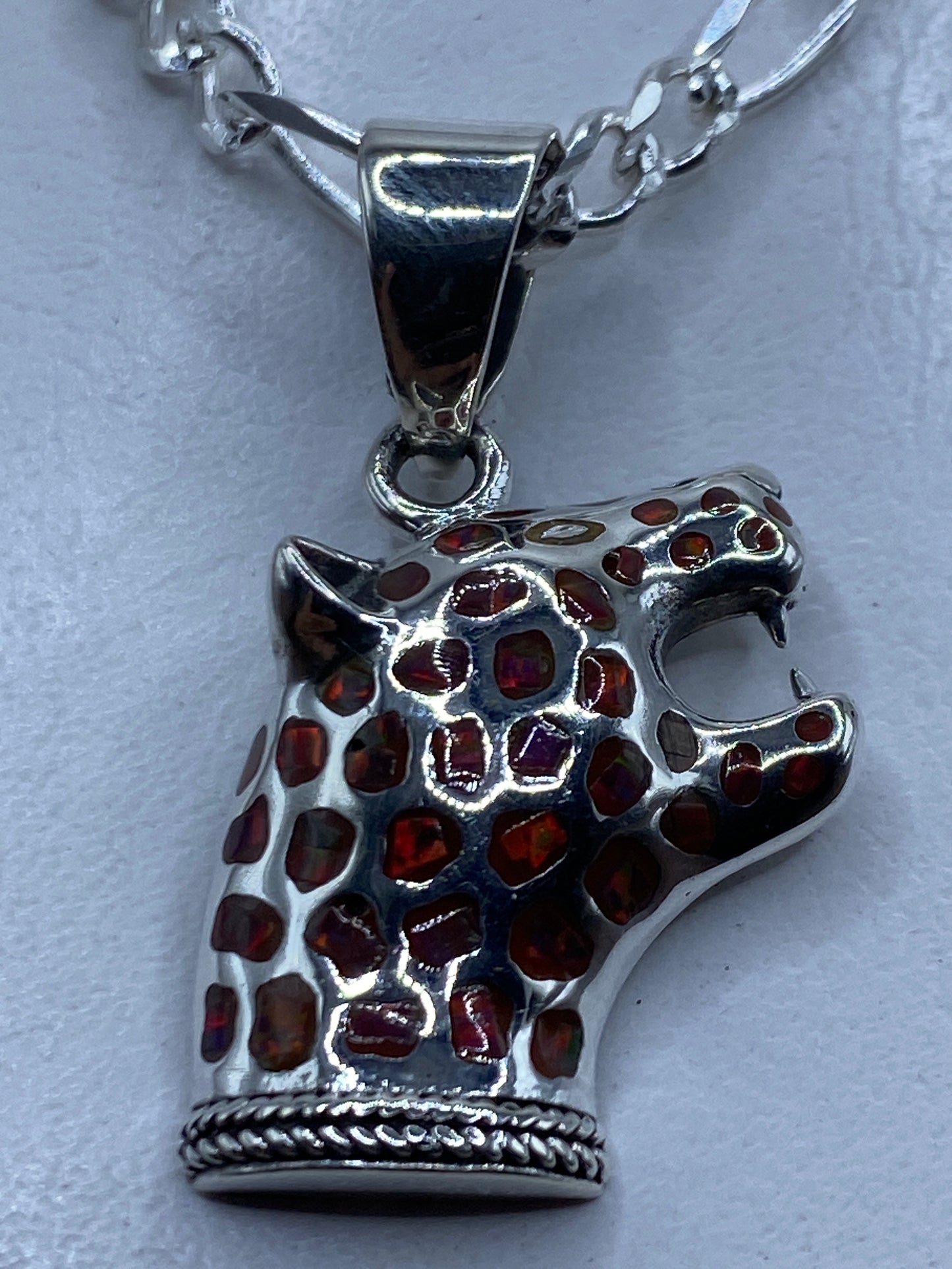 Dije jaguar de plata .950 con ópalo de fuego multicolor colgado en cadena plateada