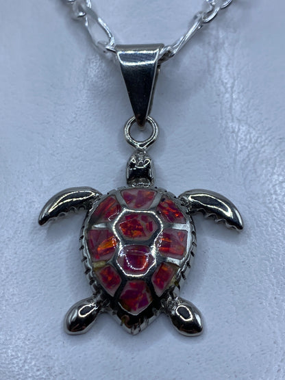 Dije tortuga marina en plata .925 con ópalo de fuego rosa incrustado, colgando en cadena