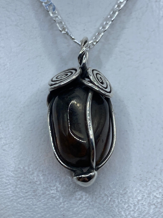 Dije de plata .925 con ámbar natural engastado, largo 3.6 cm, colgando de una cadena plateada