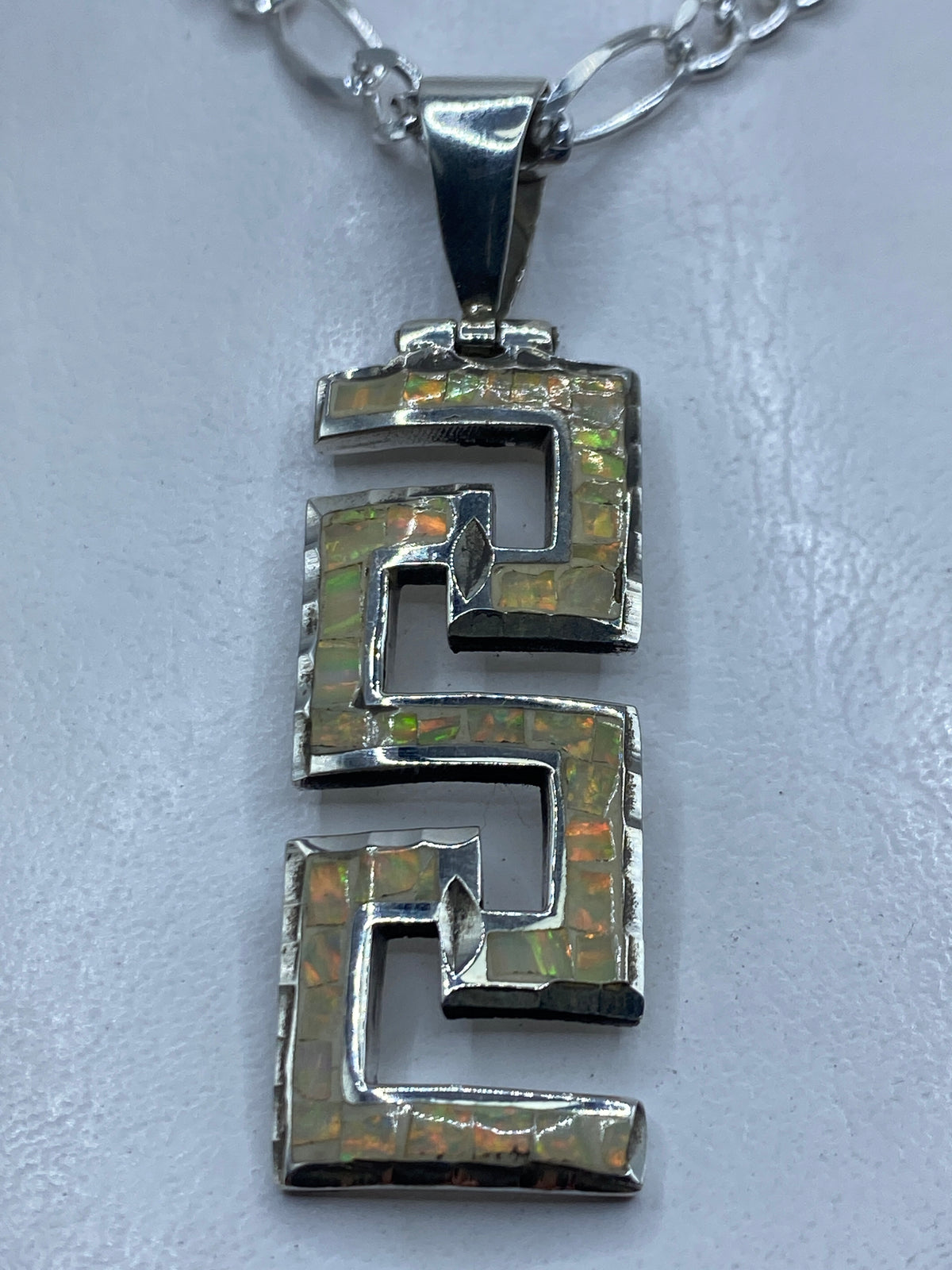 Dije de plata .950 con óptalo de fuego multicolor en diseño geométrico prehispánico, largo 6.2 cm