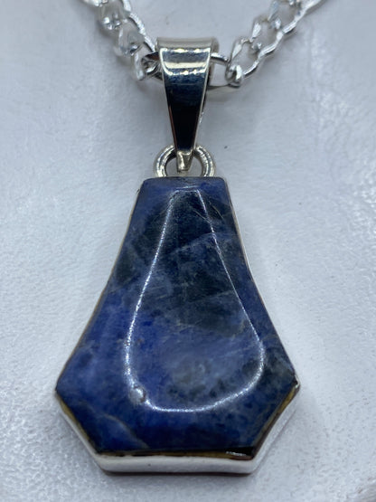 Dije hexagonal de plata .950 con piedra azul engastada a mano, colgado en cadena plateada