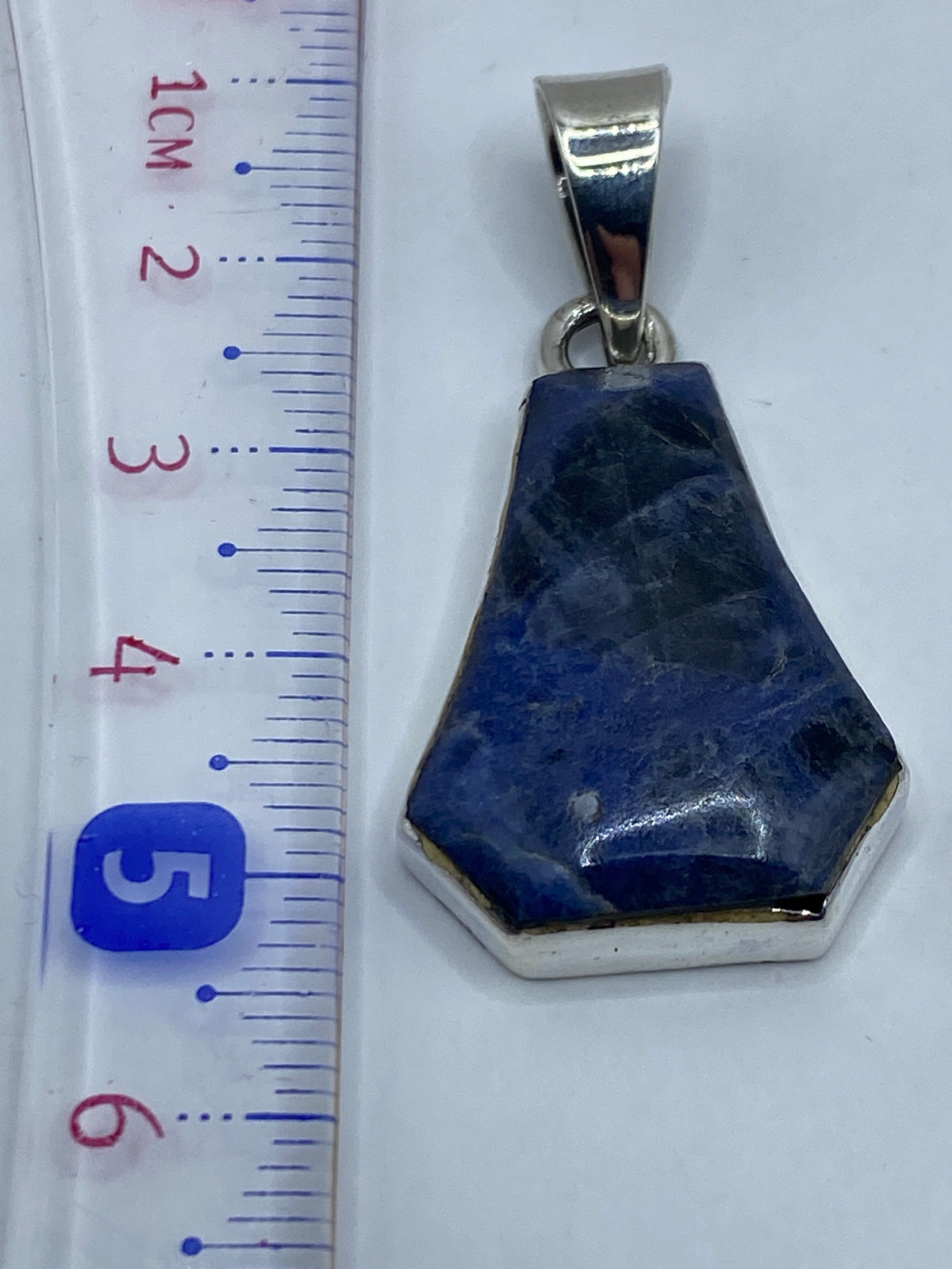 Dije de plata .950 sin cadena en fondo blanco mostrando el Quinto de autenticidad