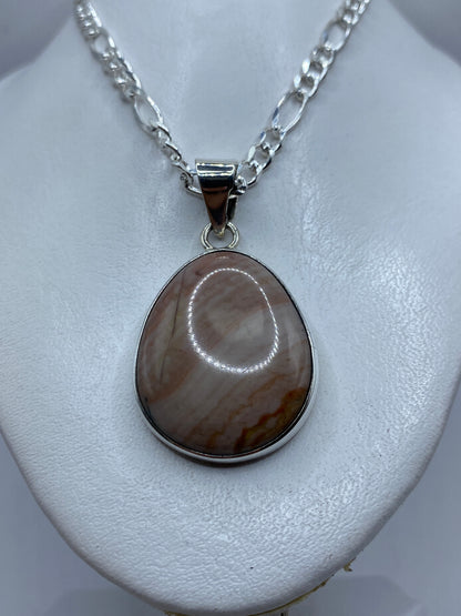 Detalle de la incrustación de piedra a mano en el dije de plata .950