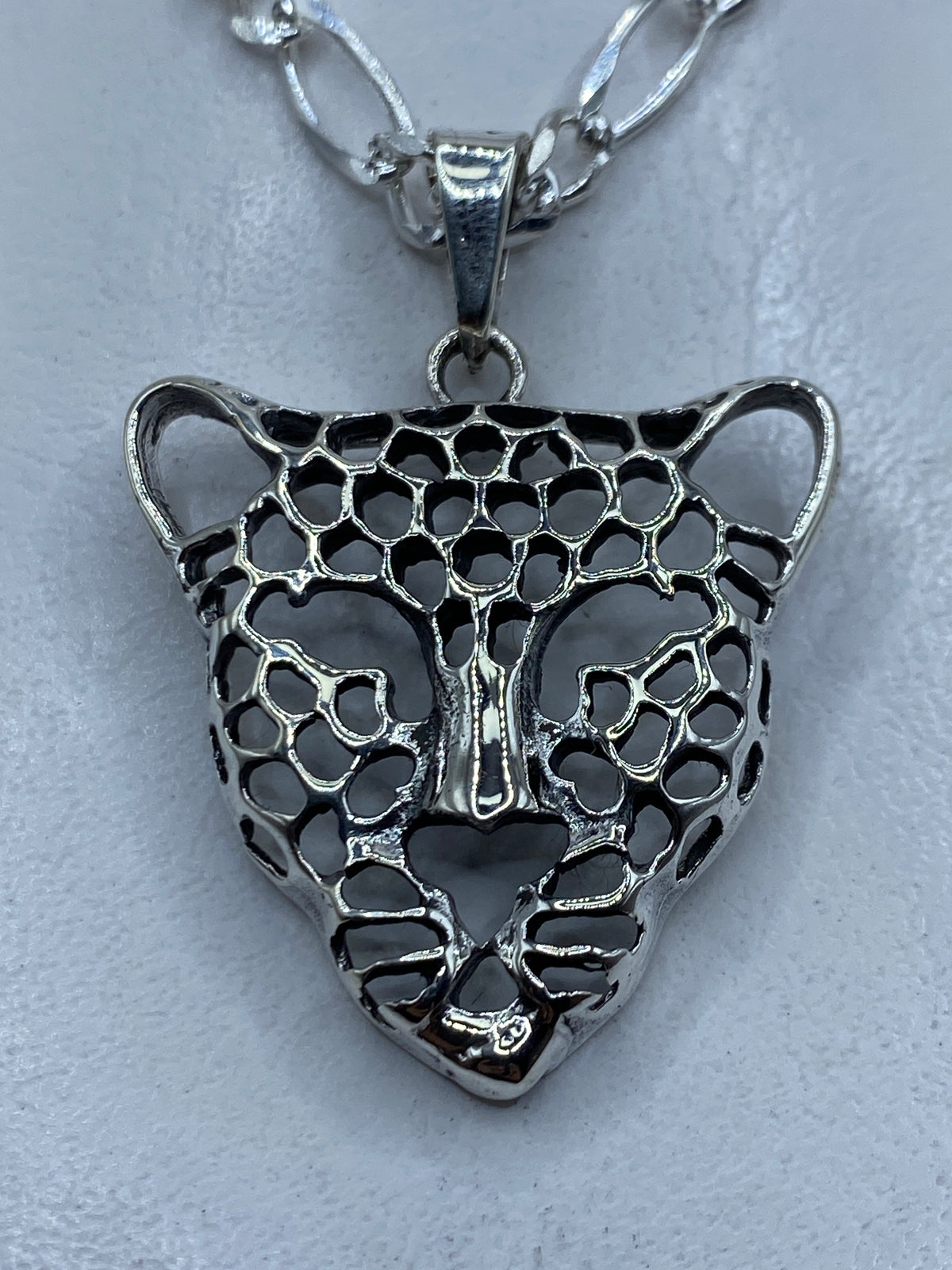 Dije de plata .925 con cabeza de jaguar en técnica de calado, mostrando el diseño en negativo