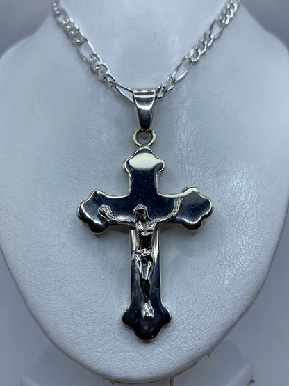 Medida del dije crucifijo de 7 cm junto a una regla, mostrando su tamaño visible