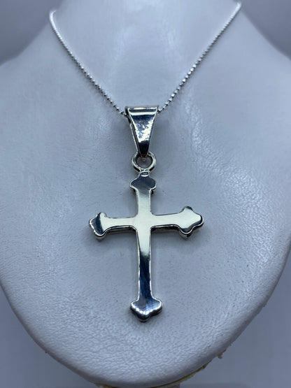 Cruz de plata Taxco con Quinto 925 colgada en collar sobre pecho