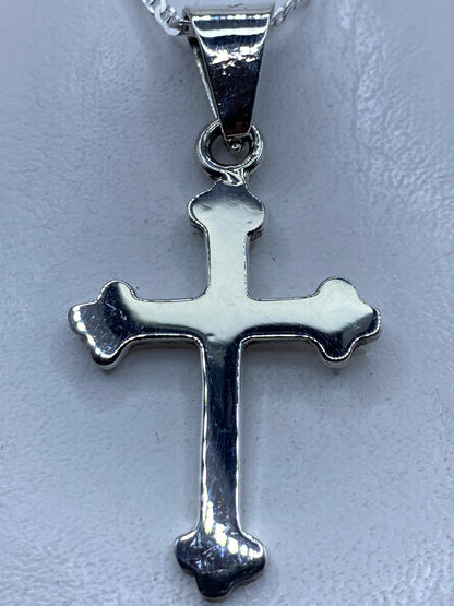 Dije cruz de plata .925 con forma clásica y redondeada, colgante en cadena plateada