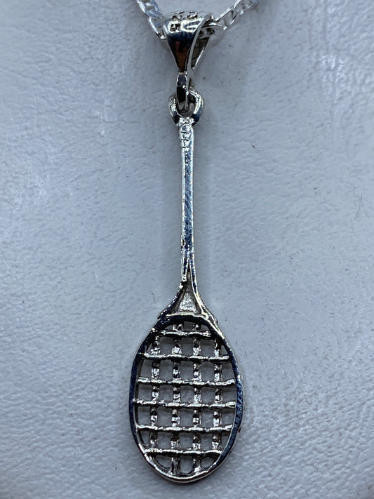 Dije de plata en forma de raqueta de tenis, calado, colgando de una cadena en el cuello