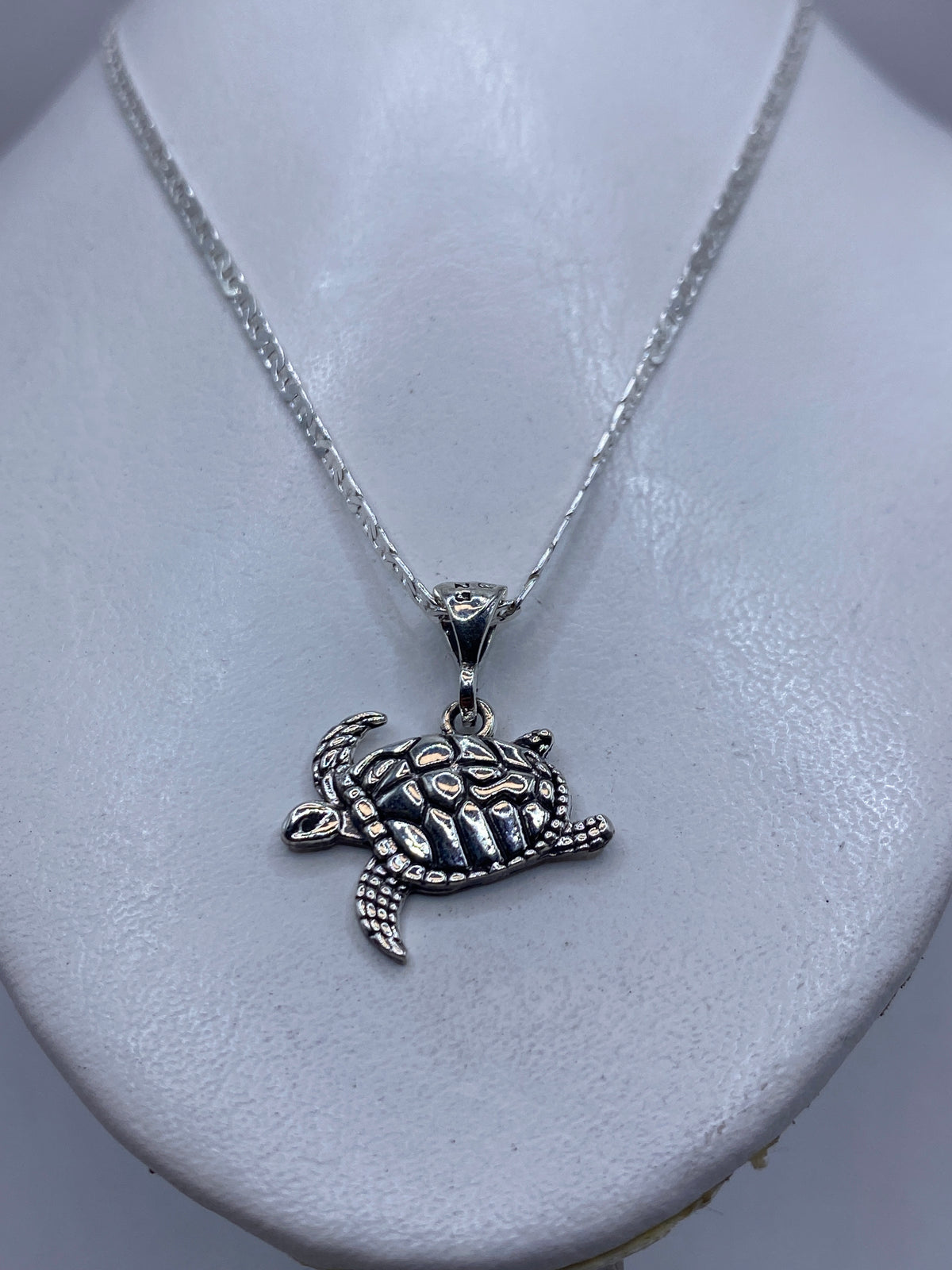 Detalle del repujado artesanal de la tortuga marina — cada línea de la coraza martillada a mano