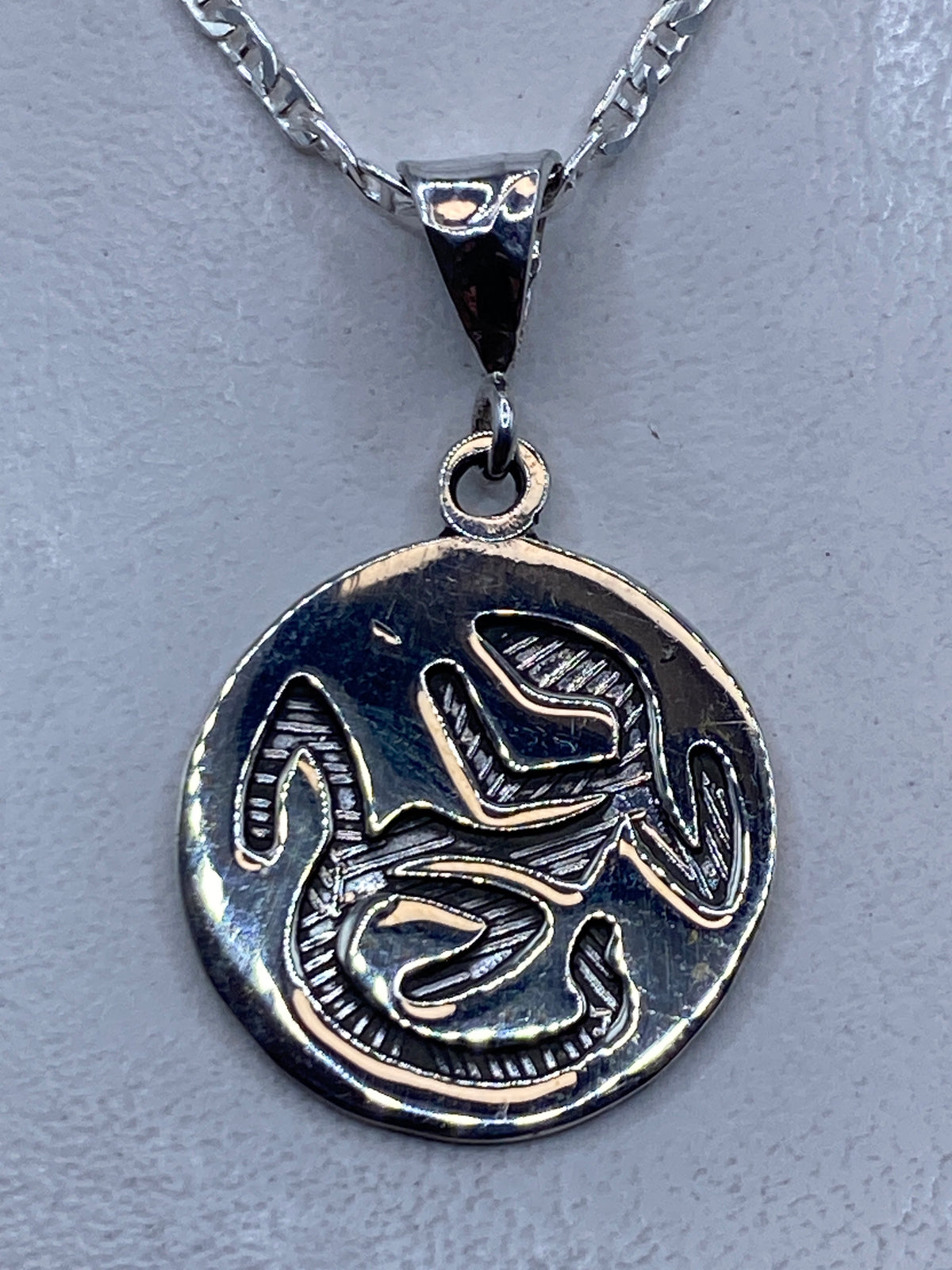 Dije prehispánico de plata .925 repujado con motivos geométricos aztecas, 4.3 cm colgando de cadena