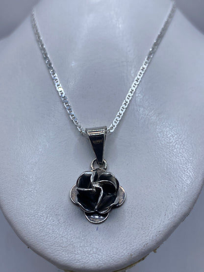Dije floral rosa sobre cadena de plata, llevado al cuello