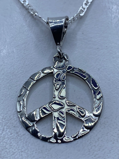 Dije símbolo de paz calado en plata .925 sobre fondo blanco