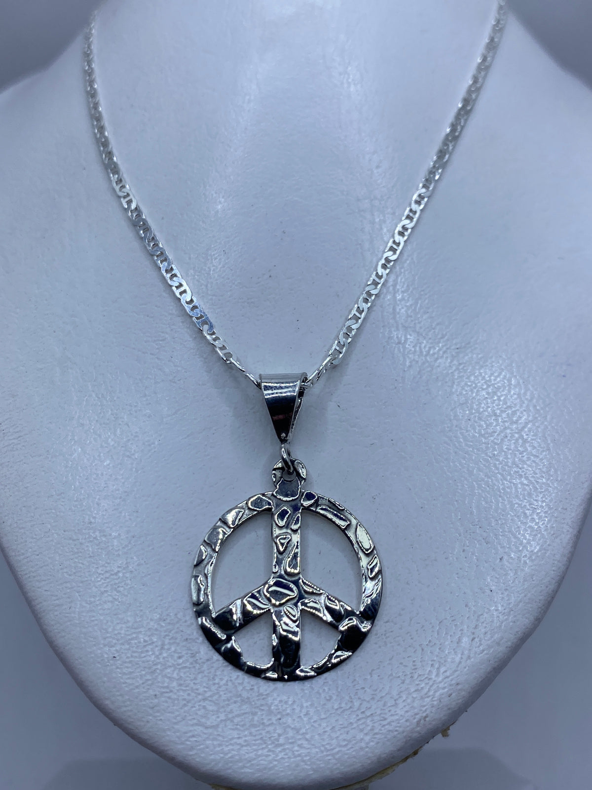 Dije de paz en plata .925 con medida de 4.3 cm junto a regla para referencia de tamaño