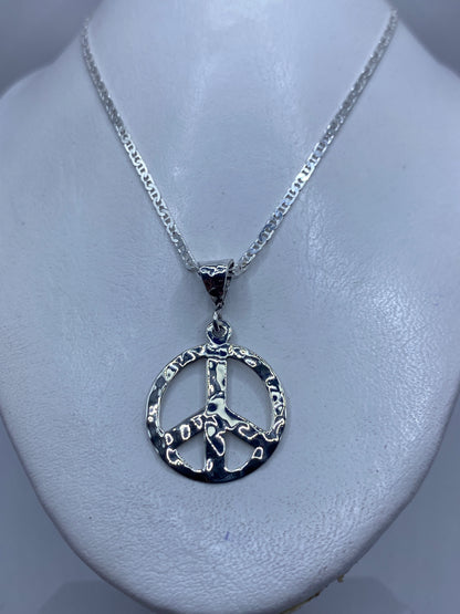 Detalle del relieve del símbolo de paz en plata pulida