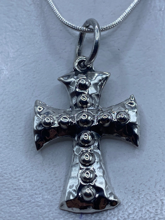 Dije de cruz en plata .925 con esferas de granulado de Taxco, colgando de una cadena plateada
