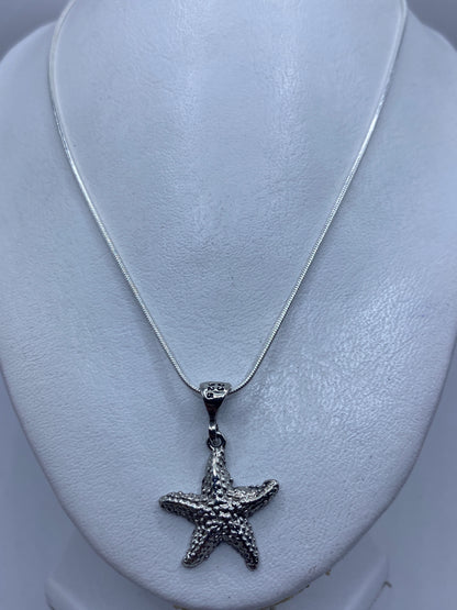 Detalle cercano del dije estrella de mar mostrando las bolitas de plata soldadas a mano