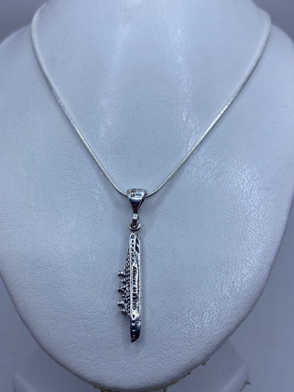 Detalle lateral del dije minimalista con la ansa de sujeción en plata