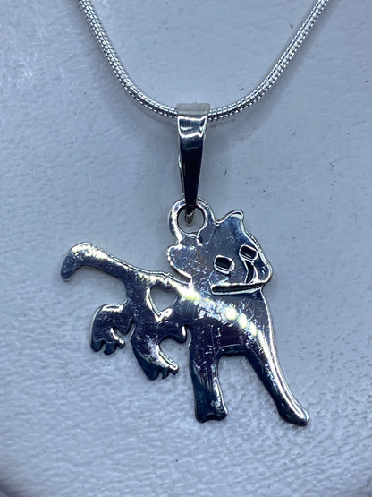 Dije de plata gato minimalista en cadena, detalle frontal del rostro felino