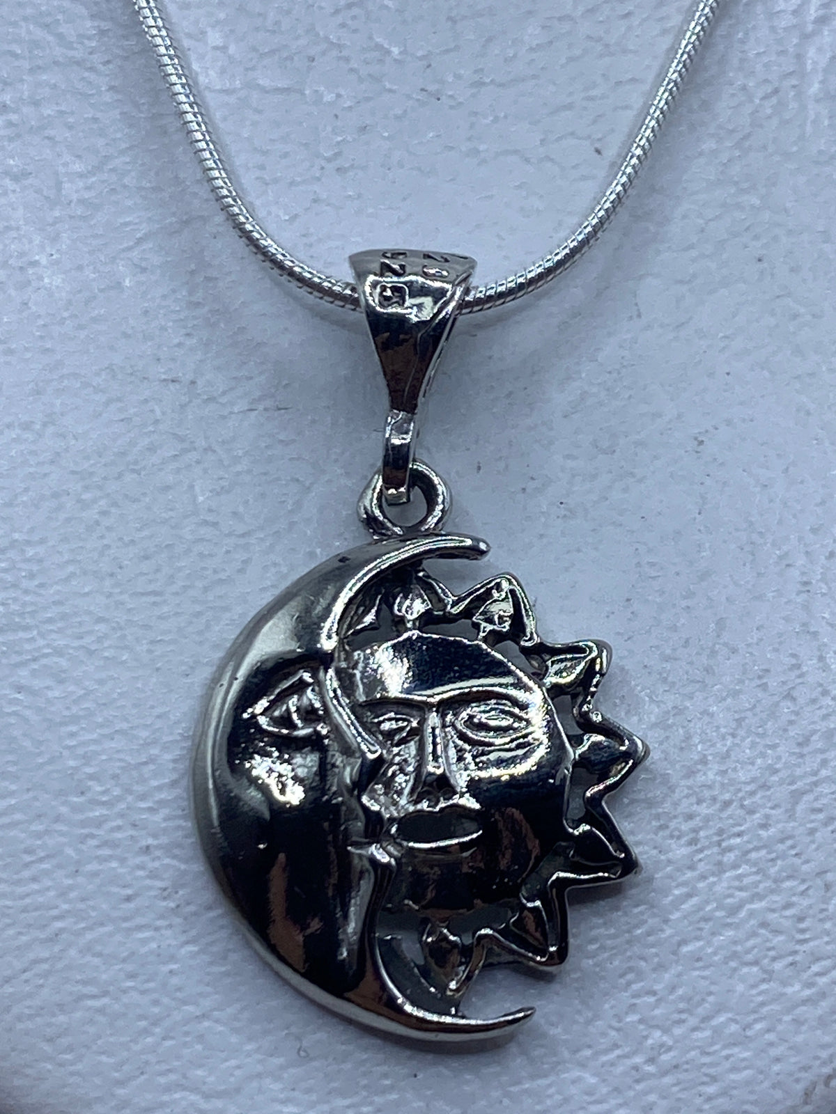 Dije de plata repujado con luna y sol en relieve, colgante de cadena, vista frontal