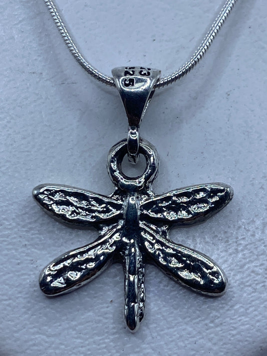 Dije de libélula en plata .925 colgando de una cadena serpentina sobre pecho