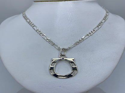 Detalle del dije de plata con acabado artesanal y líneas geométricas