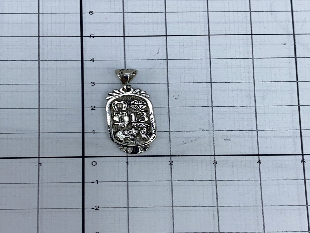 Dije sobre cadena plateada a modo de referencia de tamaño
