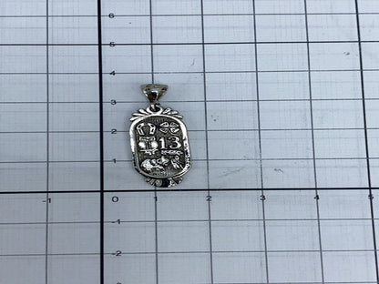 Dije sobre cadena plateada a modo de referencia de tamaño