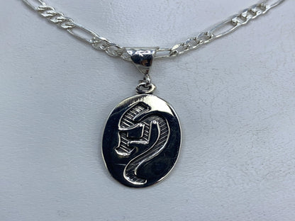Dije de plata repujado de 3 cm sobre cadena figaro en plata .925