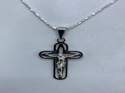 Dije crucifijo de plata .925 con calado, frente donde se ve el relieve y los cortes delicados
