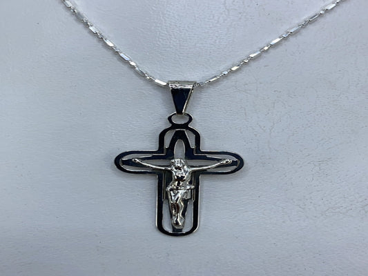 Dije crucifijo de plata .925 con calado, frente donde se ve el relieve y los cortes delicados