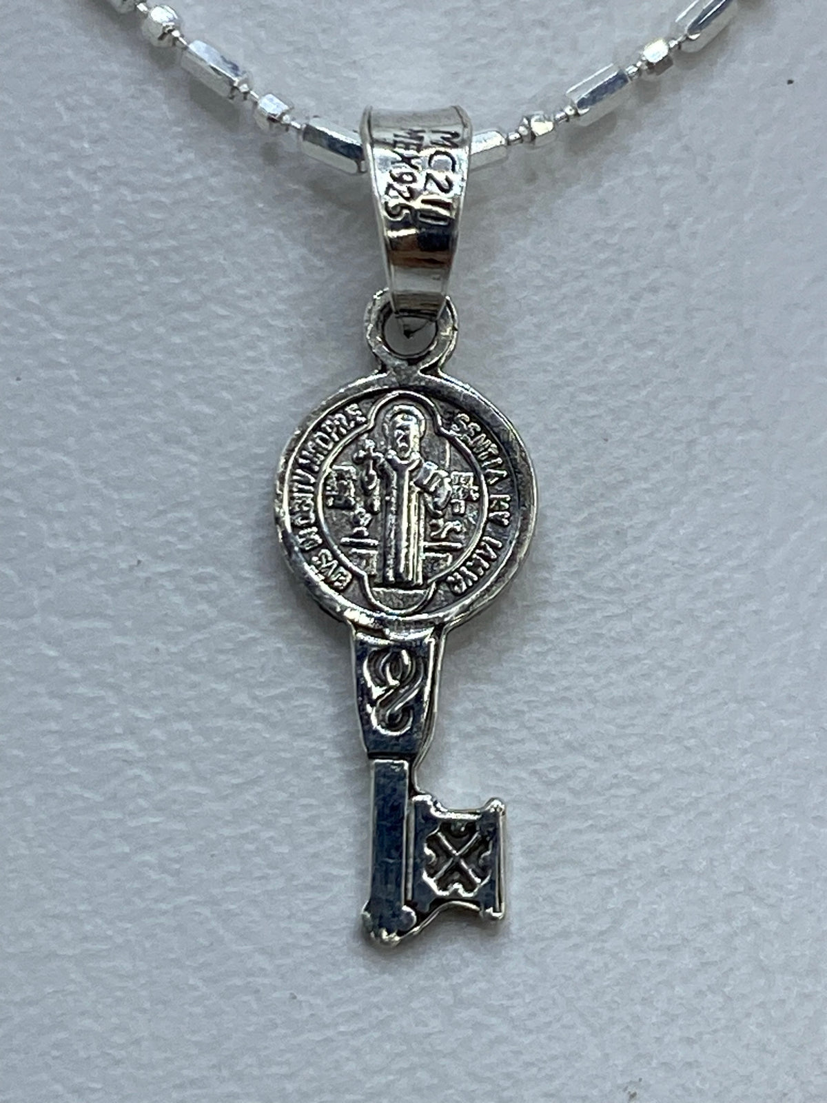 Dije San Benito de plata .925 repujado, frente con la imagen del santo en relieve