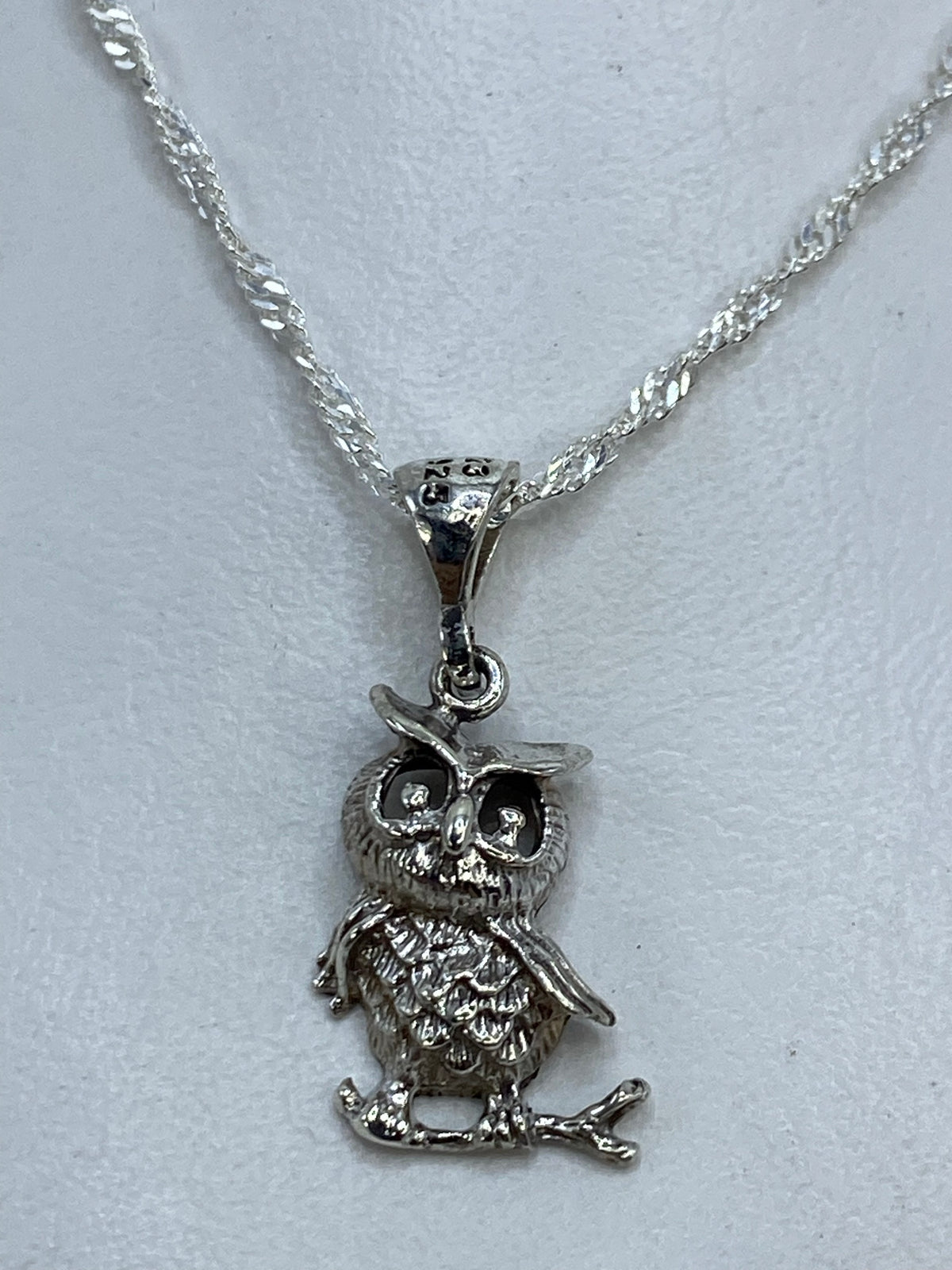 Dije búho fundido en plata con alas en relieve