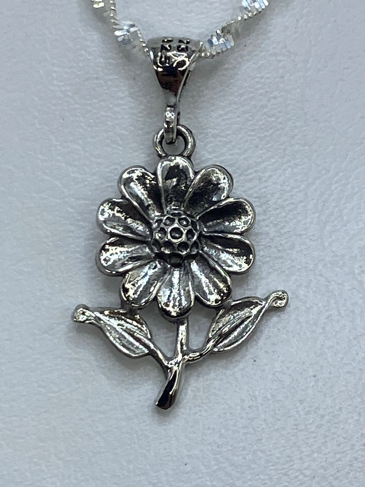 Dije flor de plata repujada en cadena de eslabones finos de plata