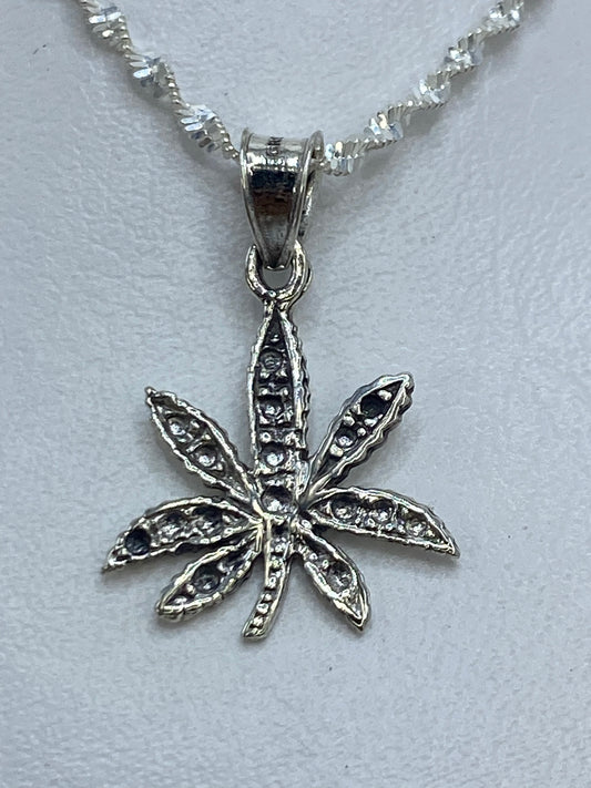 Dije de plata ocho pétalos de 3 cm de largo sobre cadena plateada